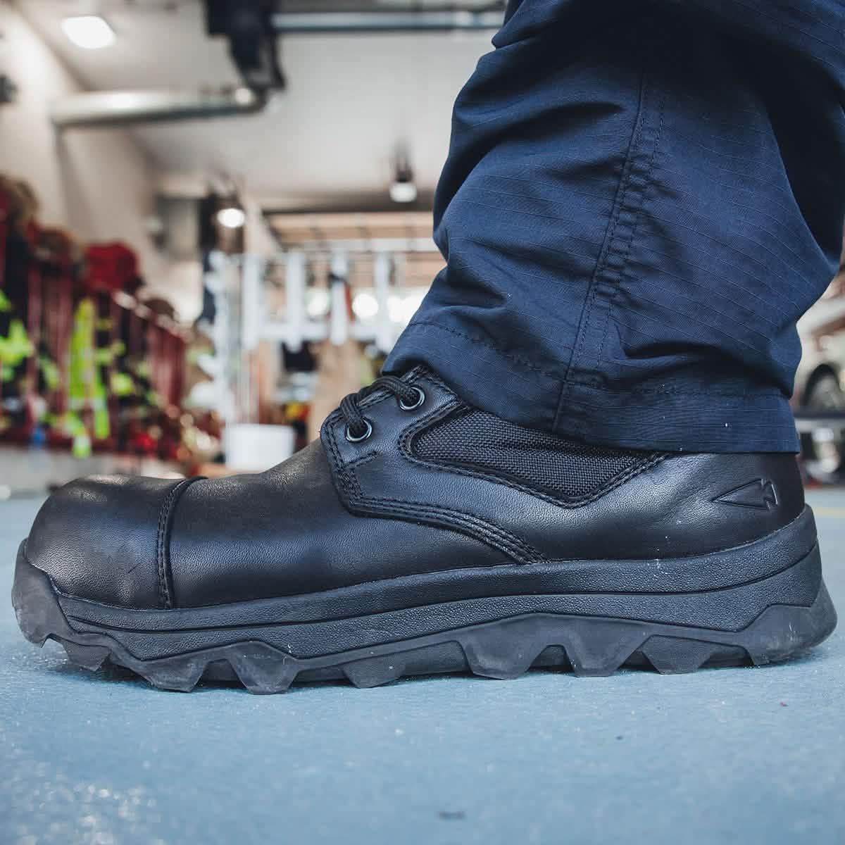 GORUCK rugged black tactical boot on concrete floor, worn by person in navy pants indoors