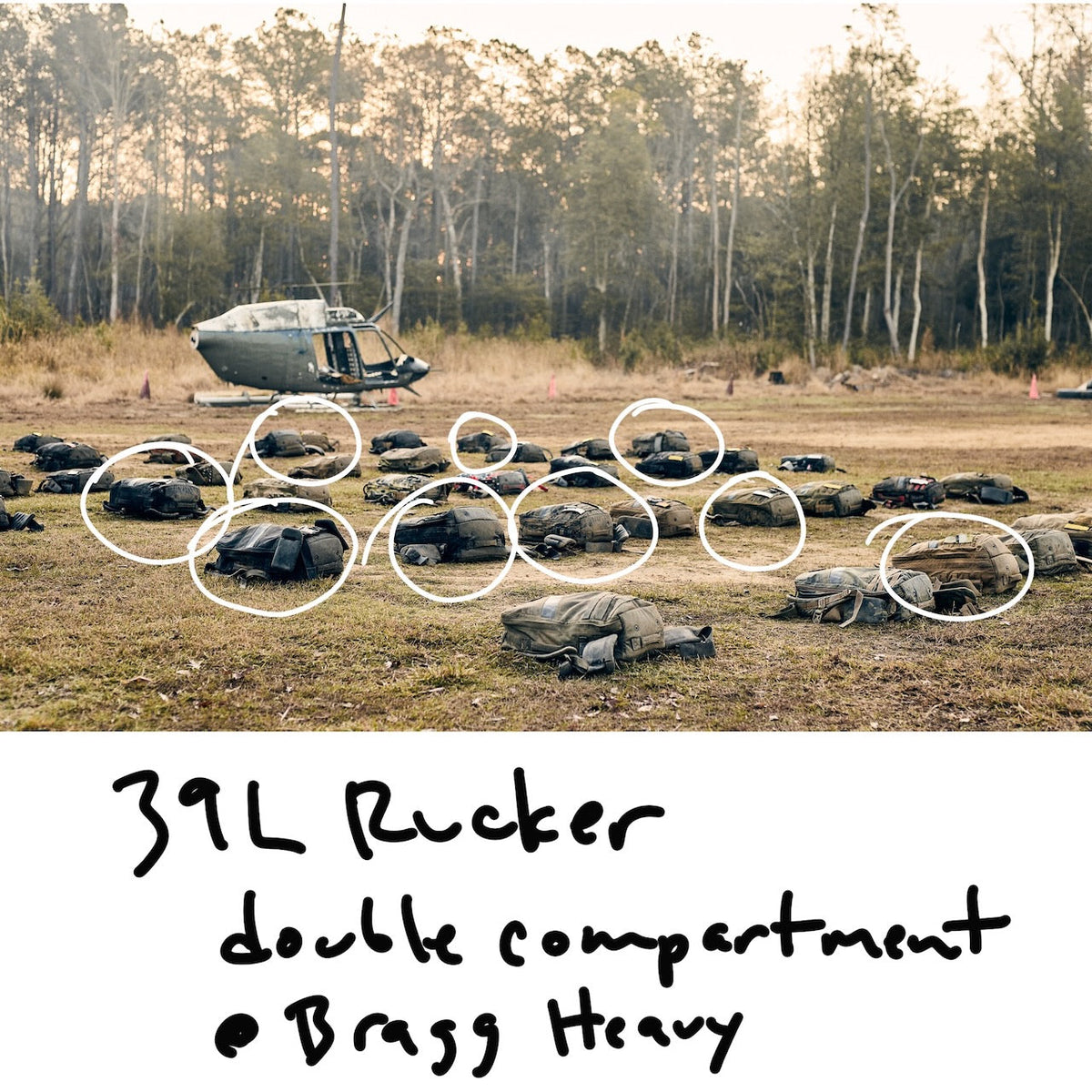 Many endurance rucksacks are scattered across a field in front of a parked helicopter, with several circled in white. Handwritten text below reads “39L Rucker double compartment Bragg Heavy.”