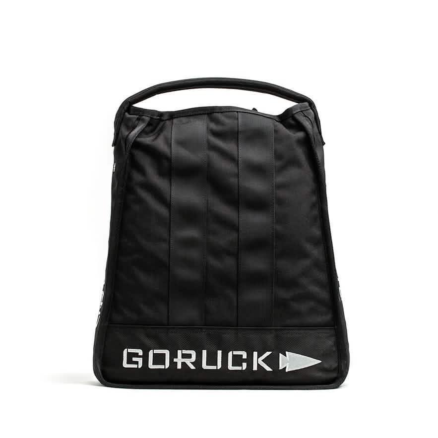 Introducing the Sand Jerry Can by GORUCK: a black backpack featuring a sleek, minimalist design constructed from Special Forces Grade materials. It includes a practical top handle, and the GORUCK name along with their signature pointed arrow logo are prominently displayed in white on the bottom front, reflecting its rugged reliability akin to a Jerry Can.