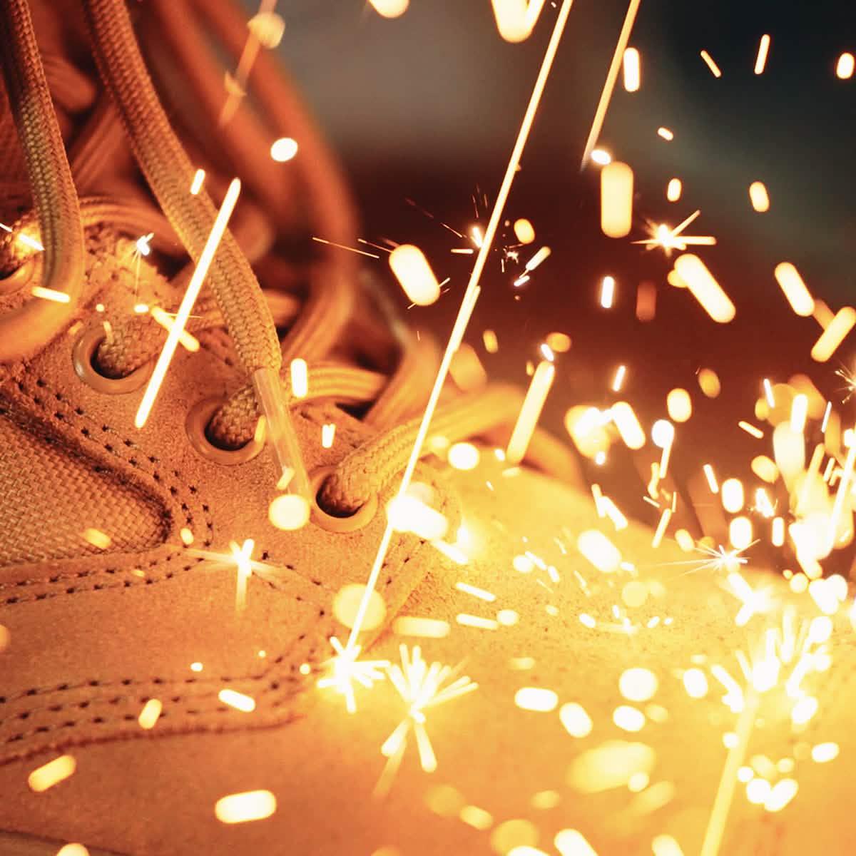 GORUCK tan rucking boot with sparks flying, showcasing tough, durable footwear.