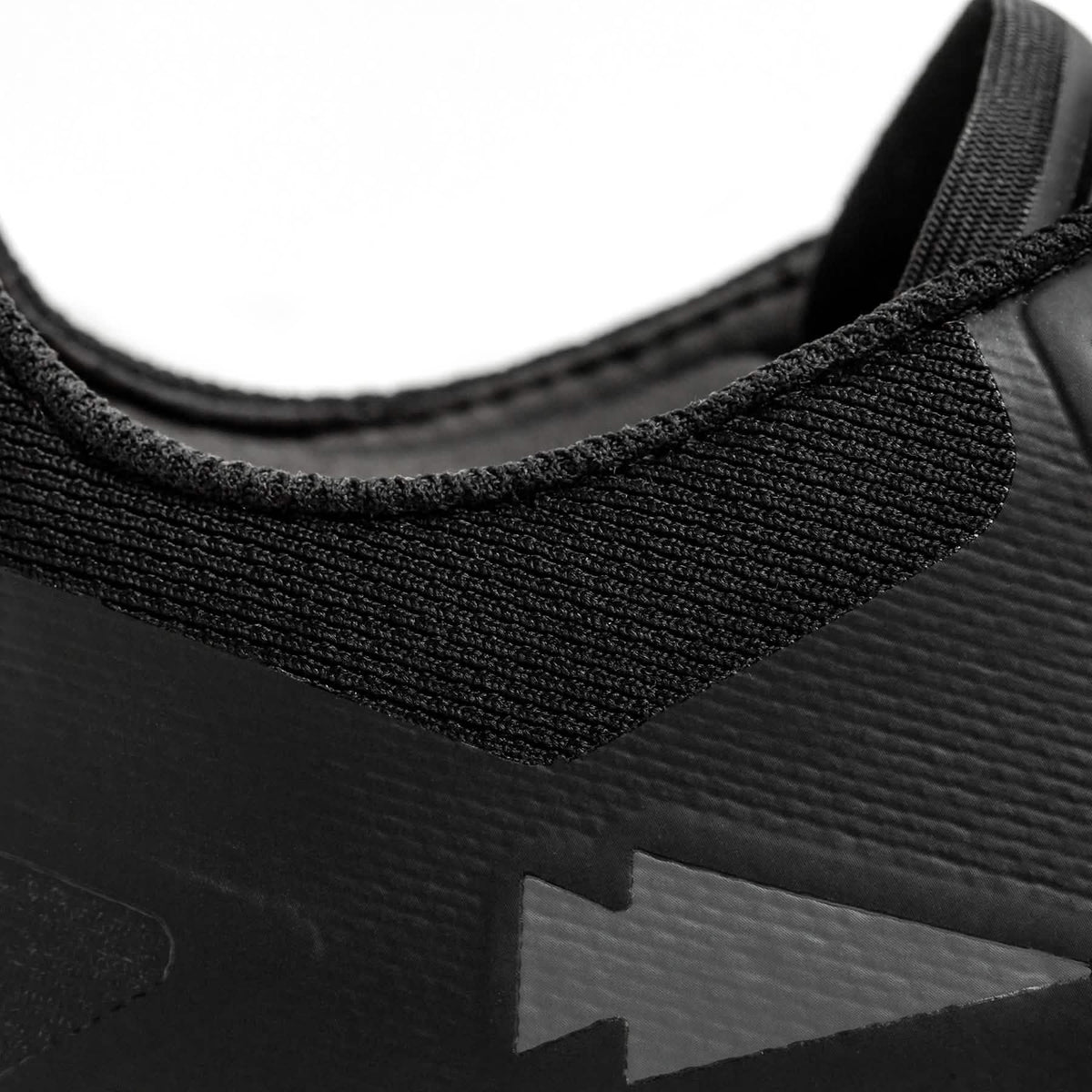 Close-up of black GORUCK rucking shoe heel with stitched fabric and arrow design