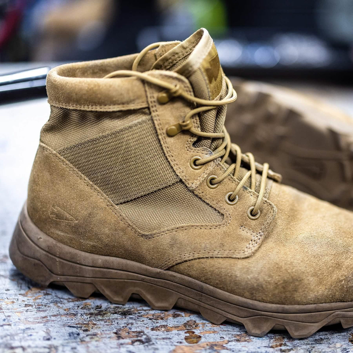 GORUCK tan rucking boot with rugged sole on a textured surface, close-up view
