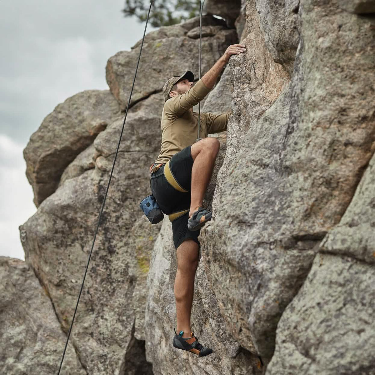 Man rock climbing outdoors in GORUCK Challenge Shorts and gear