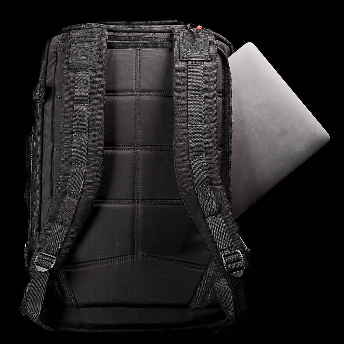 The GR3 is a black 45L travel backpack featuring padded straps and a bombproof laptop compartment, shown with a laptop partially inserted in the back compartment.