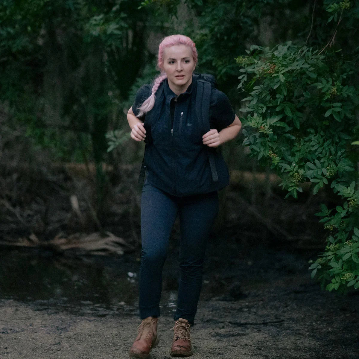 Woman with pink hair rucking in GORUCK gear and boots on a forest trail, outdoor adventure
