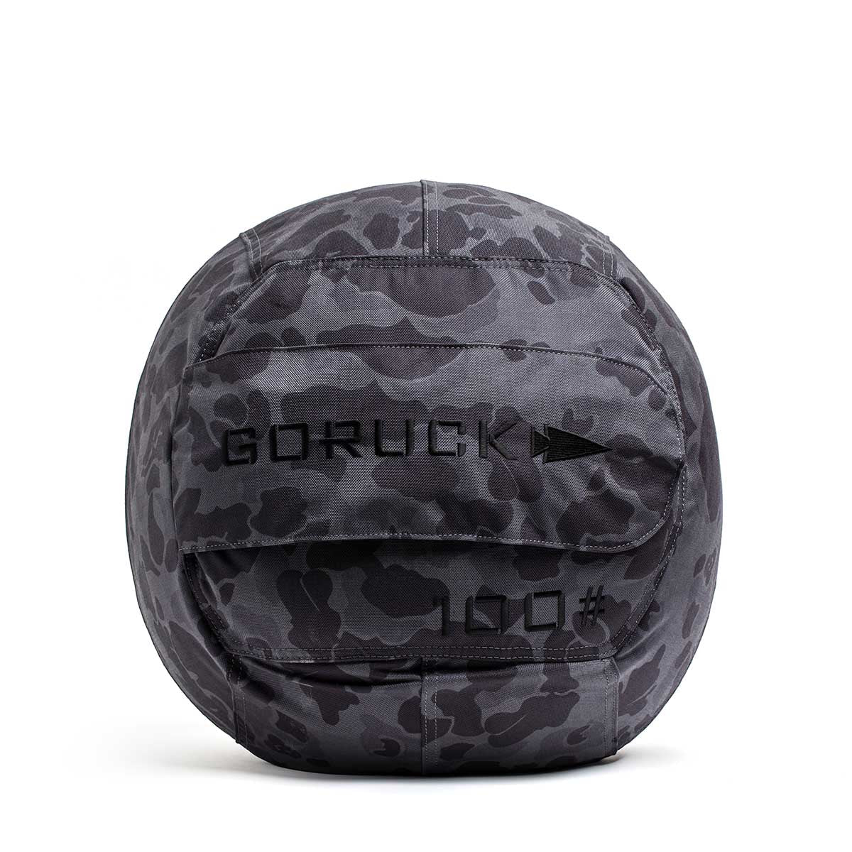 The Sand Medicine Ball features a gray camo pattern with "GORUCK" and "100" on the front, making it ideal for core stability workouts in your home gym.