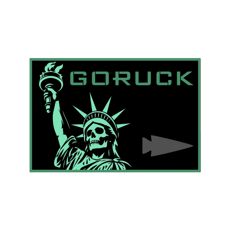A rectangular patch featuring a skull version of the Statue of Liberty holding a torch, with “GORUCK” and a gray arrowhead icon to the right, representing the Liberty’s Torch WOD.