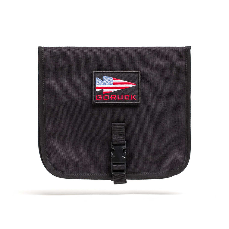 The Wire Dopp is a black pouch with an American flag patch and "GORUCK" text, front buckle closure—ideal as a travel organizer or cable pouch for your EDC essentials.