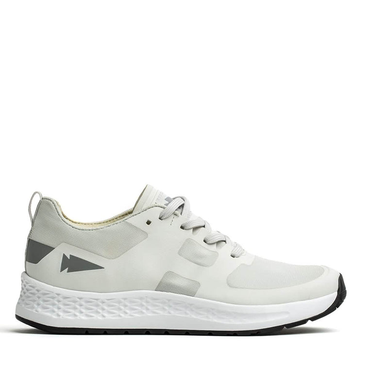 Introducing the GORUCK Rough Runner - Light Grey + Dark Grey: This athletic shoe boasts a sleek, performance-enhancing design with gradient density. It features light gray accents on the heel adorned with an arrow-like graphic, while the textured white midsole seamlessly pairs with a black outer sole. Gray laces are threaded through ingeniously designed channels for added style and functionality.