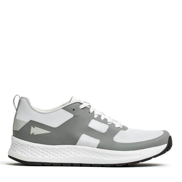 The GORUCK Rough Runner - White + Speed Grey athletic sneaker features a textured sole in the side view, with a white upper complemented by speed grey overlays. It includes white laces and a pull tab at the heel. The modern design is enhanced for high mileage running by the Gradient Density™ EVA Midsole.